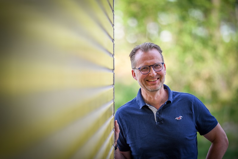 Petteri Karling leaning against a wall and smiling.